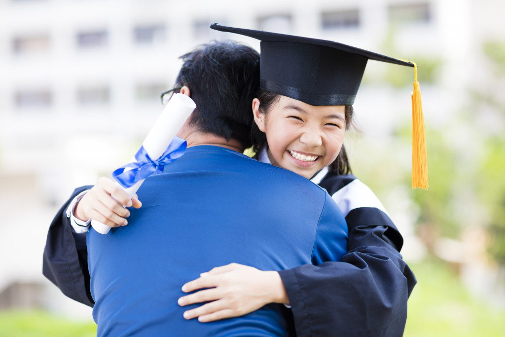 a father hugging little girl during a graduation ceremony