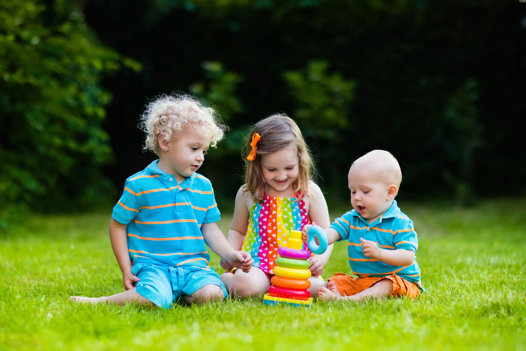 3 kids outdoor playing with toys