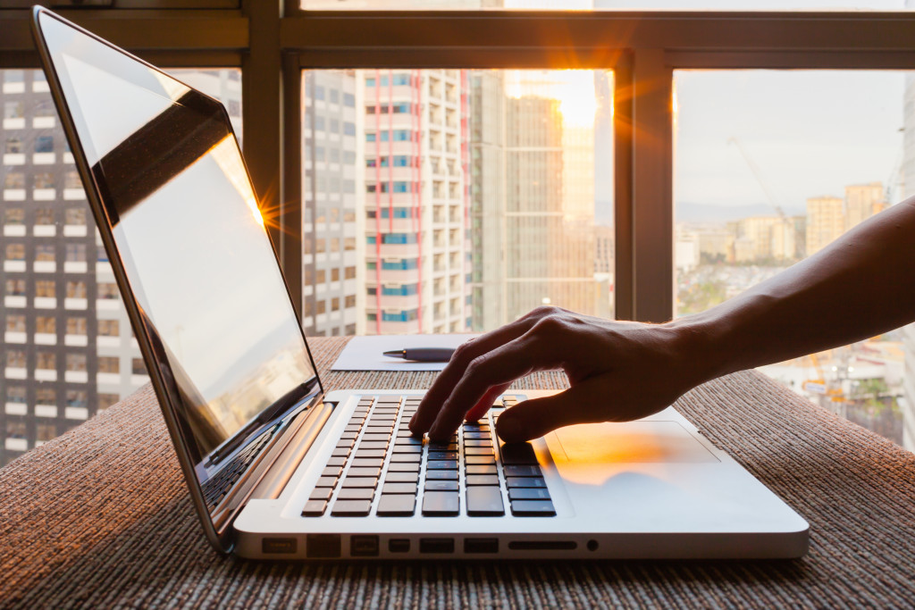 A hand on a laptop in an office